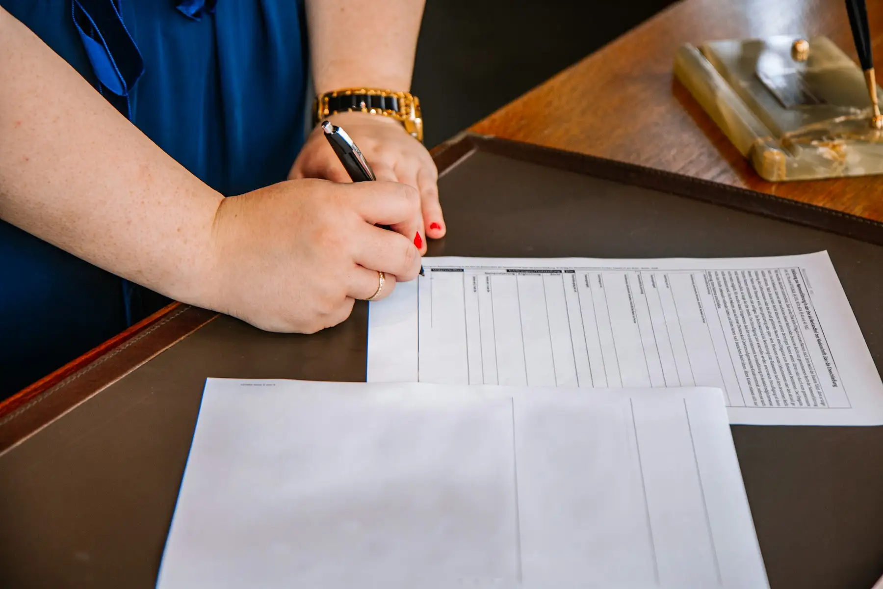 Person filling in a form by hand at a desk