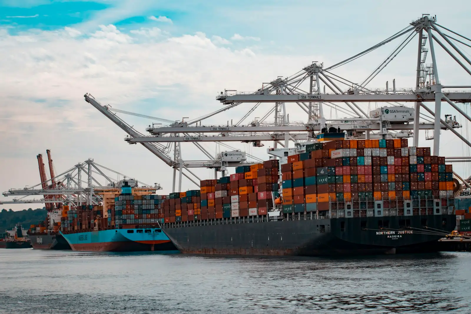 Container ship being loaded by cranes at a port